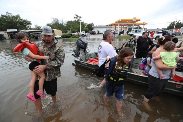 Un grupo de vecinos ayuda a evacuar a unos niños al sureste de Houston. Univisión/Reuters.